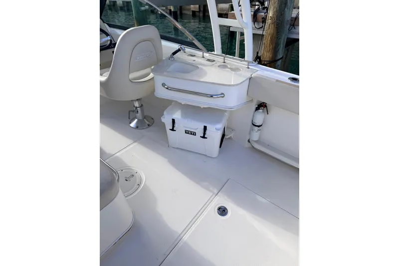 Slide: The Image of 2016 Boston Whaler 230 Vantage interior with seating, cooler, and fire extinguisher. - 7