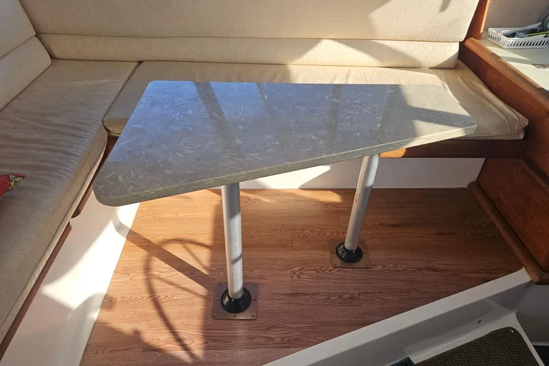 Slide: The Image of 1994 Bayliner 3288 Motoryacht interior with cushioned seating and a sleek table. - 15