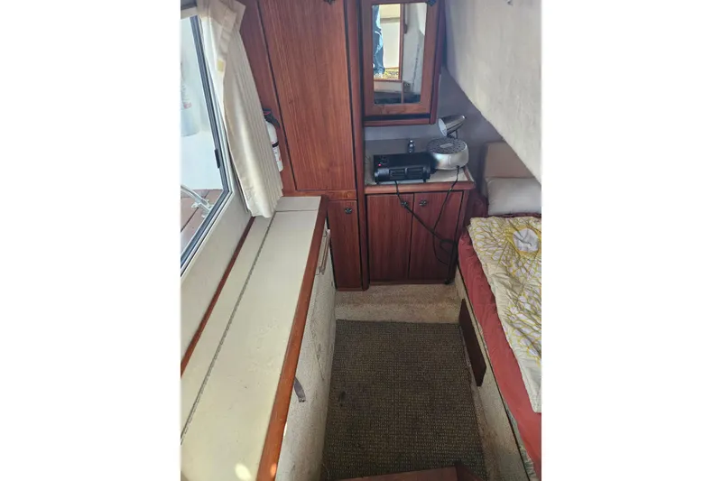 Slide: The Image of 1994 Bayliner 3288 Motoryacht interior with wood cabinetry and cozy sleeping area. - 19