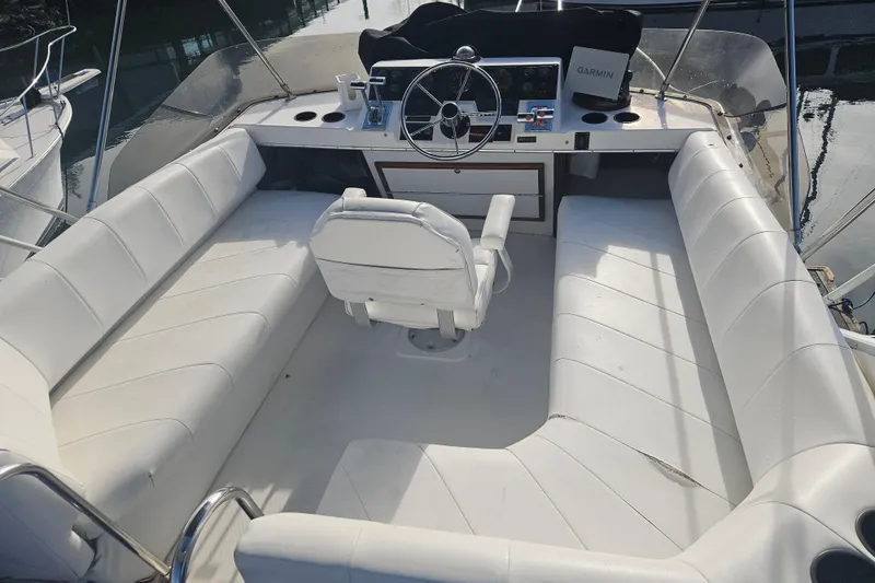 Slide: The Image of 1994 Bayliner 3288 Motoryacht cockpit with white seating and steering console. - 2