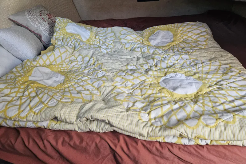 Slide: The Image of Cozy bed with patterned yellow and white comforter inside 1994 Bayliner 3288 Motoryacht cabin. - 21