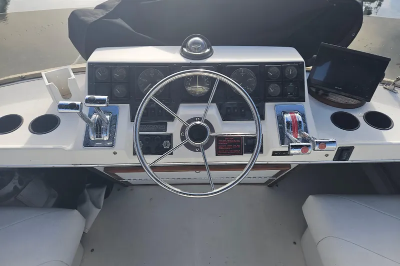 Slide: The Image of 1994 Bayliner 3288 Motoryacht helm with steering wheel, controls, and gauges. - 3