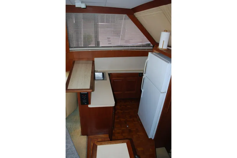 Slide: The Image of 1988 Viking 45 Convertible yacht kitchen with wood cabinetry, sink, and refrigerator. - 14