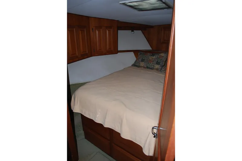 Slide: The Image of Cozy bedroom in 1988 Viking 45 Convertible yacht with wooden cabinets and soft lighting. - 17