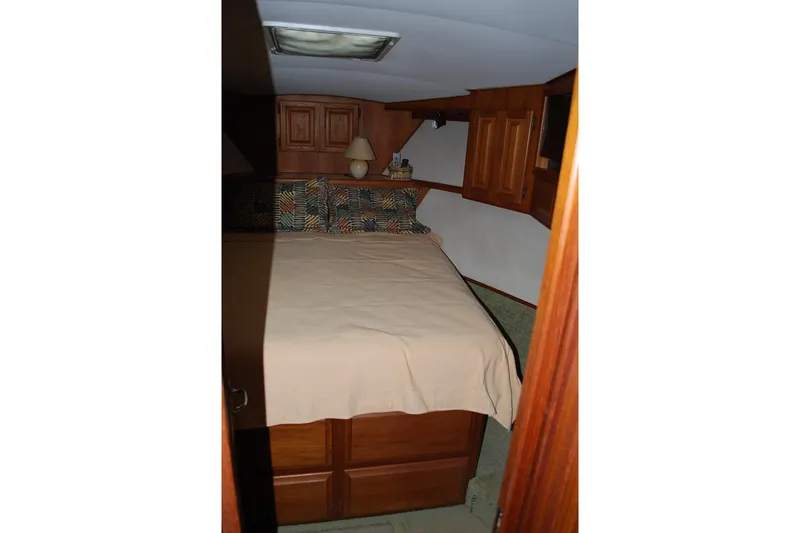 Slide: The Image of 1988 Viking 45 Convertible yacht bedroom with wooden cabinets and cozy bedding. - 18