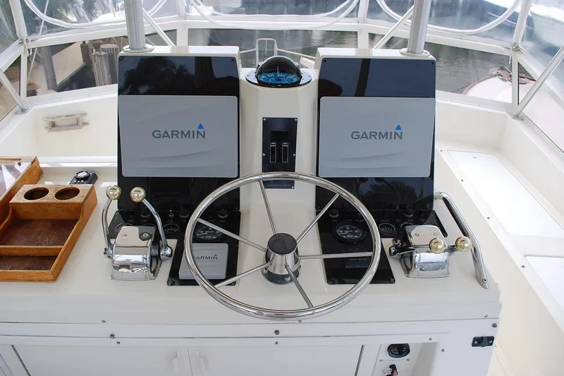 Slide: The Image of 1988 Viking 45 Convertible helm with Garmin navigation, dual controls, and steering wheel. - 6