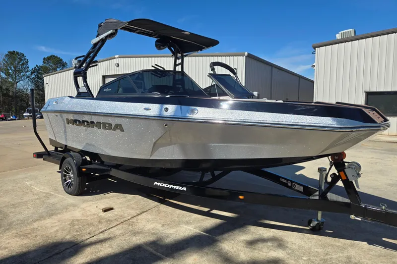 The Image of 2020 Moomba Helix boat on trailer, parked outdoors near industrial building. - 1