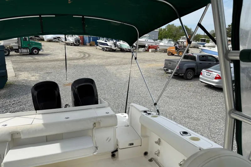 Slide: The Image of 2006 Trophy 2502 Walkaround boat interior with canopy, parked in a gravel lot. - 11