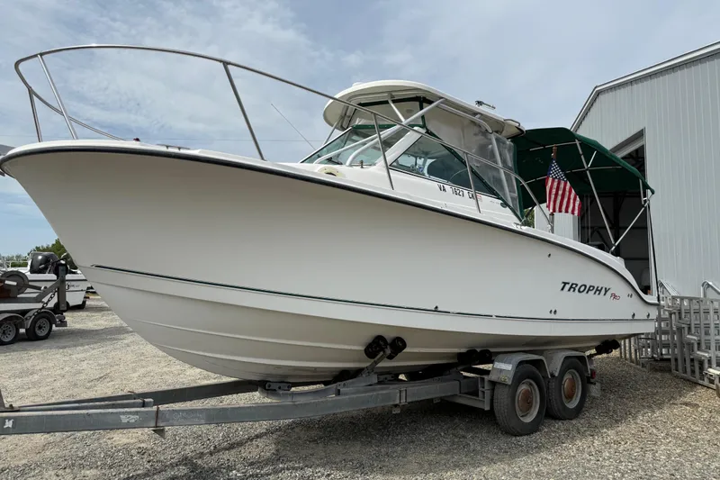 Slide: The Image of 2006 Trophy 2502 Walkaround boat on trailer, parked near a building. - 15