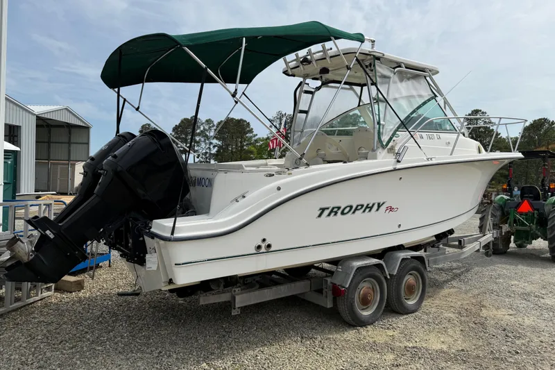 Slide: The Image of 2006 Trophy 2502 Walkaround boat on trailer with green canopy and outboard motor. - 17