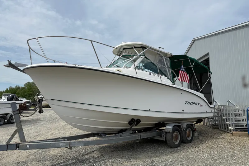 Slide: The Image of 2006 Trophy 2502 Walkaround boat on trailer near a metal building. - 18