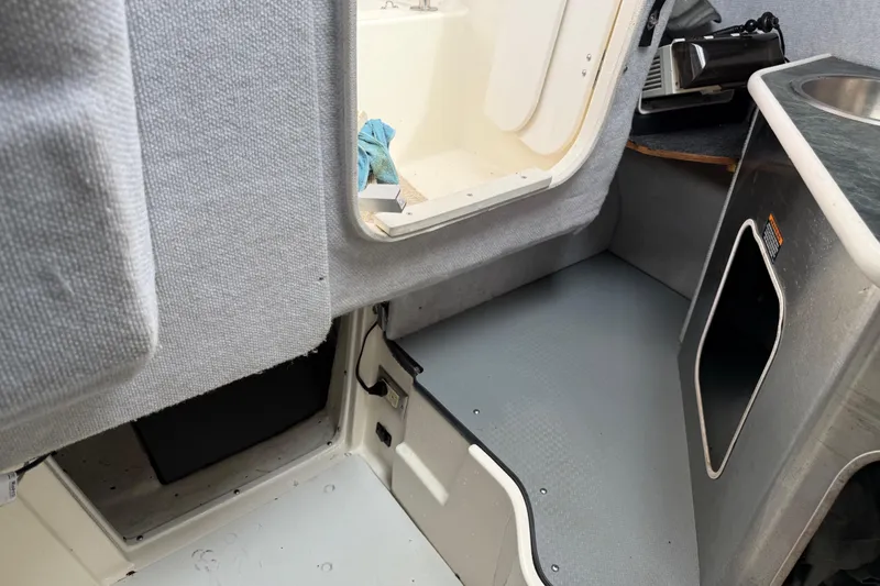 Slide: The Image of Interior of a 2006 Trophy 2502 Walkaround boat, featuring cabin entry and sink area. - 19