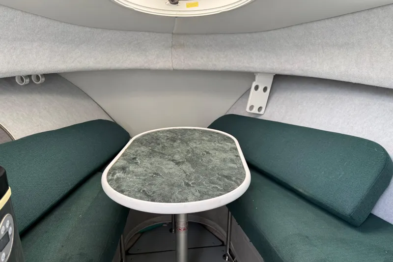 Slide: The Image of 2006 Trophy 2502 Walkaround cabin interior with green seating and a central table. - 22