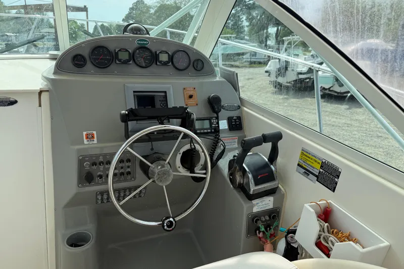 Slide: The Image of 2006 Trophy 2502 Walkaround boat dashboard with steering wheel and controls. - 28