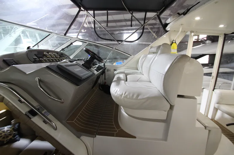 Slide: The Image of 2003 Cruisers Yachts 4450 Express Motoryacht helm with white seating and control panel. - 16