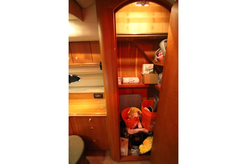 Slide: The Image of Interior storage area of 2003 Cruisers Yachts 4450 Express Motoryacht with wooden cabinetry. - 62