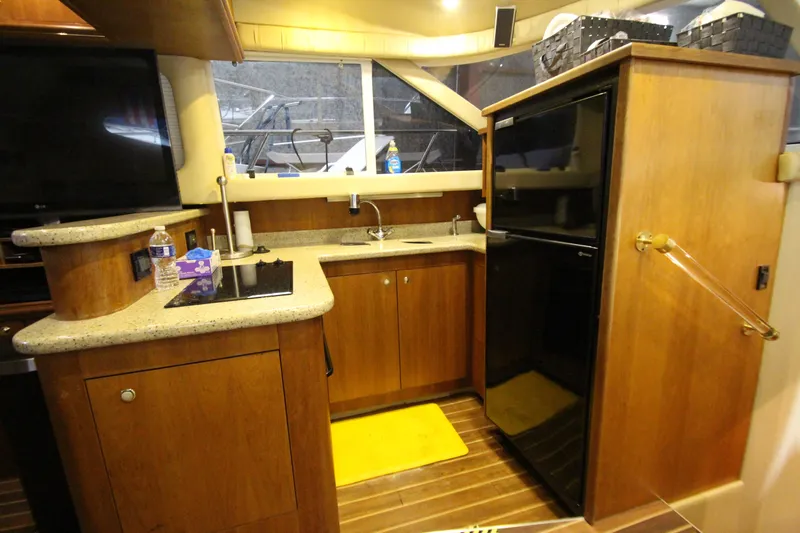 Slide: The Image of 2003 Cruisers Yachts 4450 Express Motoryacht kitchen with wood cabinetry and modern appliances. - 35