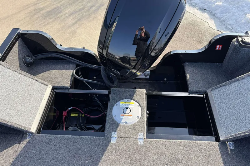 Slide: The Image of 2026 Crestliner 1850 Kodiak SC boat with open storage compartments and motor. - 8