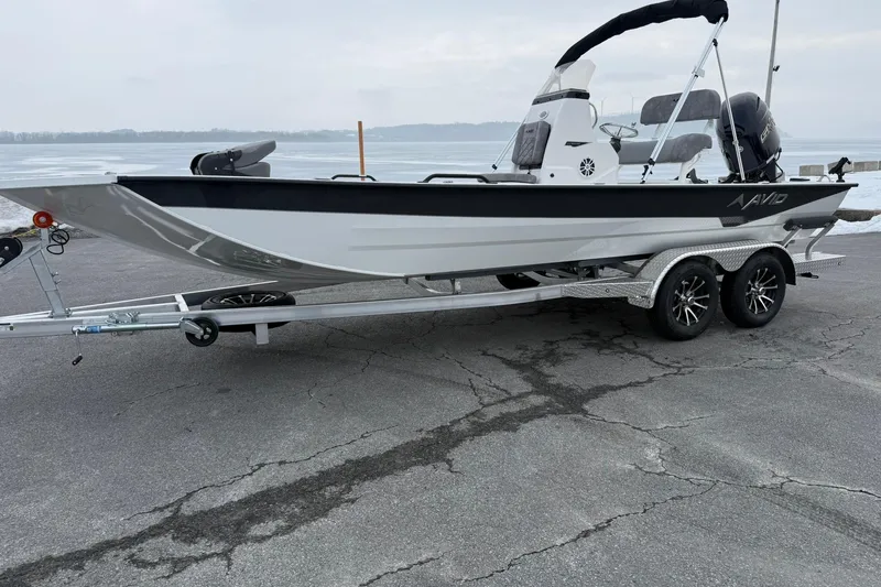 Slide: The Image of 2026 Avid 22 Recon boat on trailer by a lake, showcasing sleek design. - 1