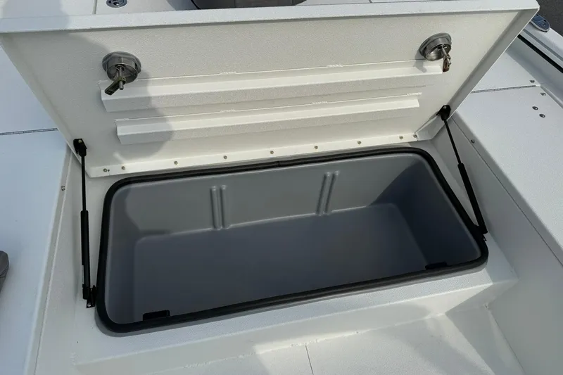 Slide: The Image of Open storage compartment on 2026 Avid 22 Recon boat, featuring secure locks and hydraulic supports. - 18