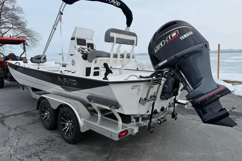 Slide: The Image of 2026 Avid 22 Recon boat with Yamaha engine on a trailer by a lake. - 3