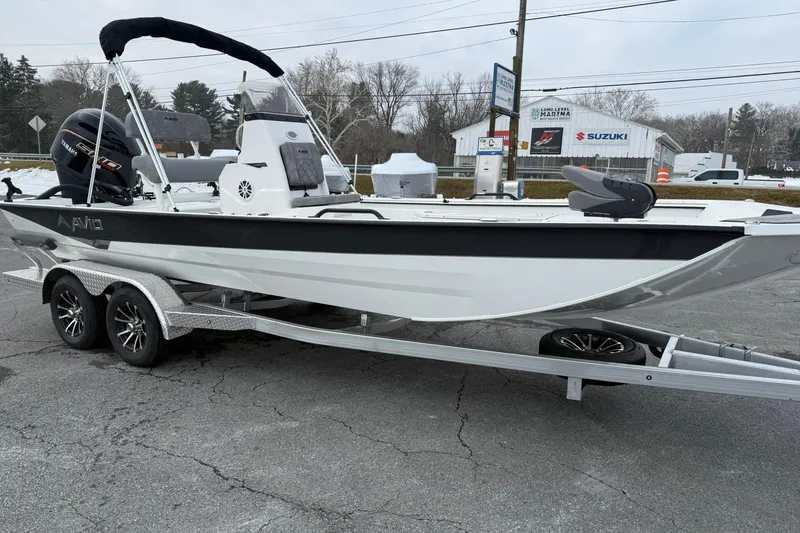 Slide: The Image of 2026 Avid 22 Recon boat on trailer, parked outdoors near Suzuki dealership. - 7