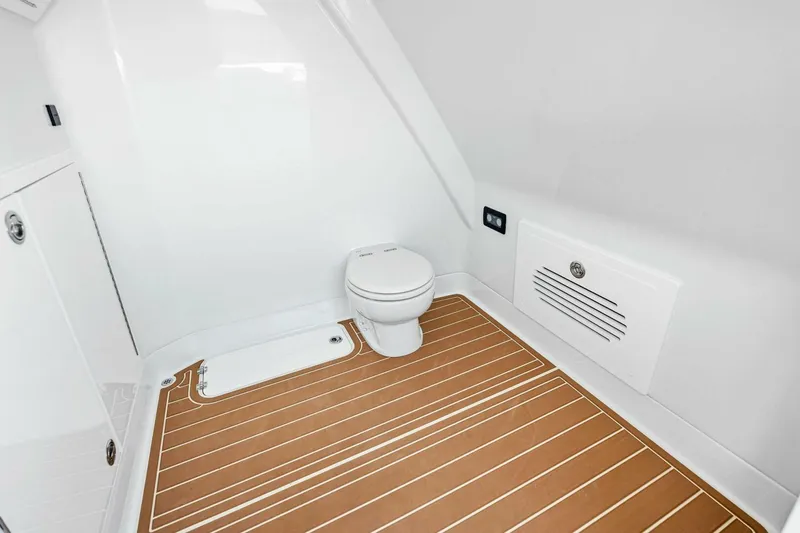 Slide: The Image of 2022 Barker Boatworks 40 HPC interior with modern marine toilet and wood-patterned flooring. - 26