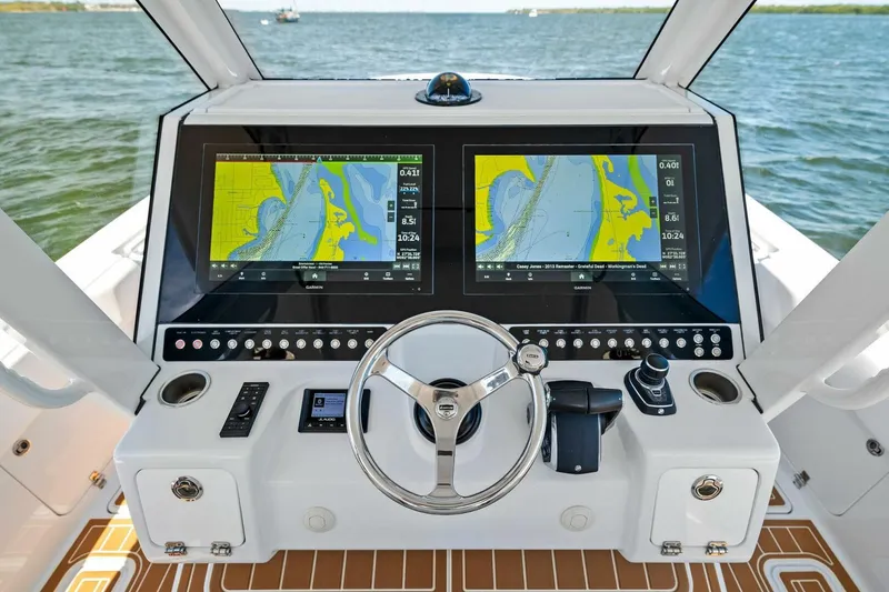 Slide: The Image of Helm of 2022 Barker Boatworks 40 HPC with dual navigation screens and steering wheel. - 12