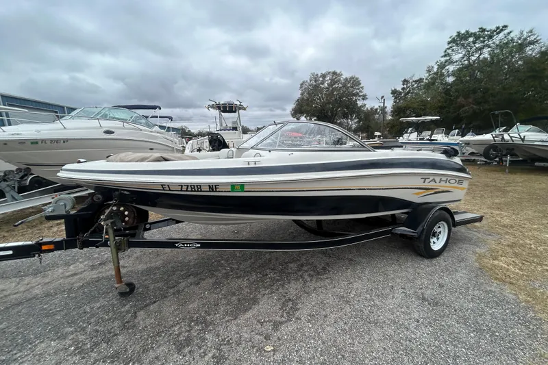 The Image of 2006 Tahoe Q4 boat on trailer, parked outdoors under cloudy skies. - 1