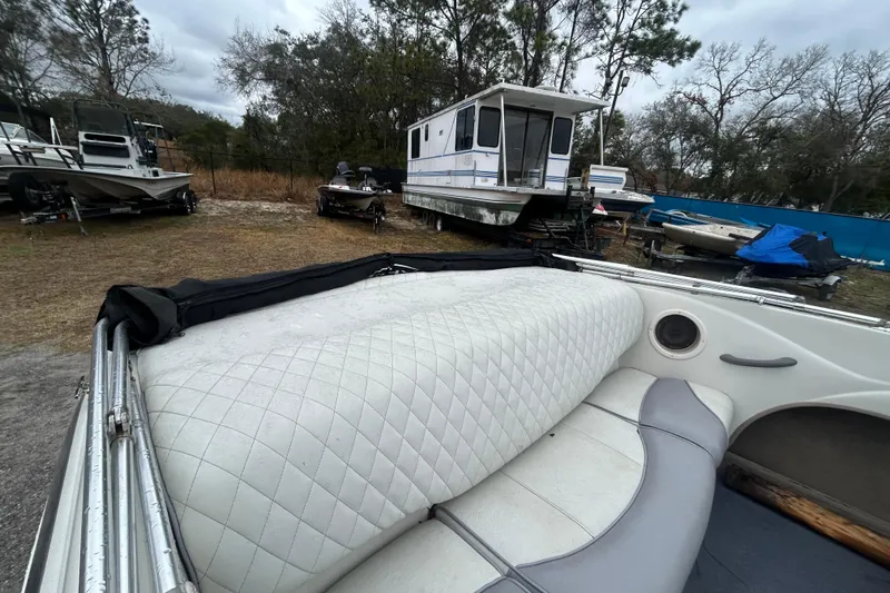 Slide: The Image of 2006 Tahoe Q4 boat interior with white quilted seating, parked near other boats. - 12