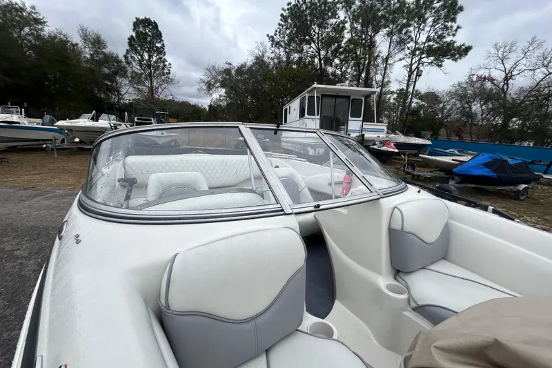 Slide: The Image of 2006 Tahoe Q4 boat with white interior, parked outdoors among other boats. - 14
