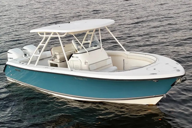 Slide: The Image of 2014 Pursuit S 280 Sport boat on calm water, featuring sleek design and twin engines. - 11