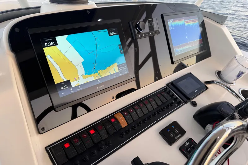 Slide: The Image of 2014 Pursuit S 280 Sport boat dashboard with navigation screens and controls. - 15
