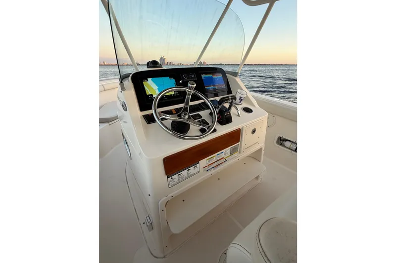 Slide: The Image of 2014 Pursuit S 280 Sport boat helm with steering wheel and navigation screens. - 16