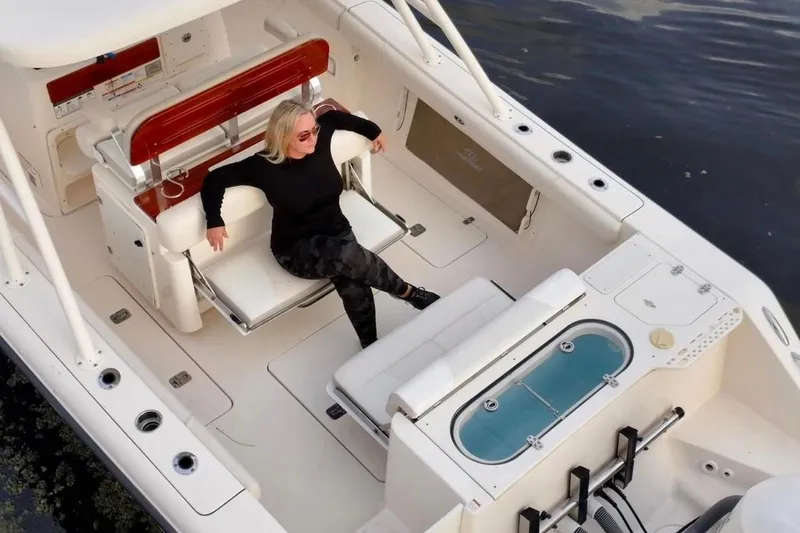 Slide: The Image of Woman relaxing on a 2014 Pursuit S 280 Sport boat, enjoying the open deck. - 32