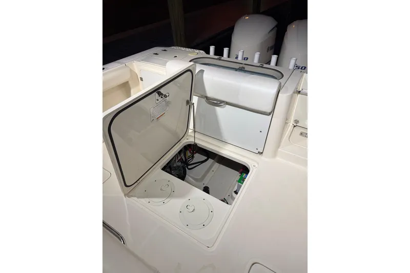 Slide: The Image of 2014 Pursuit S 280 Sport boat with open storage compartment and visible engine area. - 35