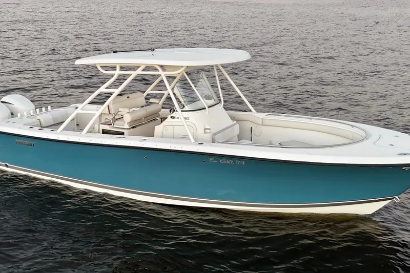 Slide: The Image of 2014 Pursuit S 280 Sport boat on calm water, featuring sleek design and blue hull. - 4