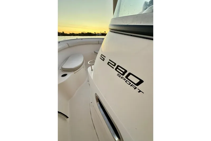 Slide: The Image of 2014 Pursuit S 280 Sport boat interior at sunset, showcasing sleek design and seating. - 42
