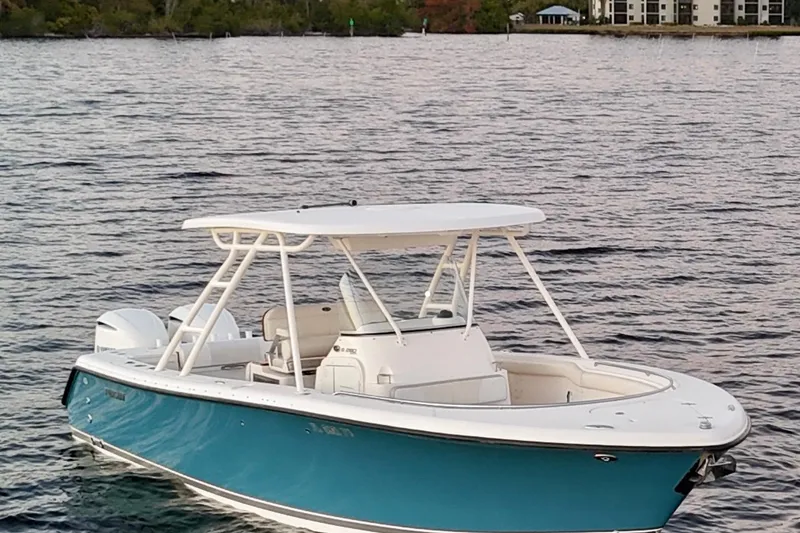 Slide: The Image of 2014 Pursuit S 280 Sport boat on calm water, featuring a sleek blue and white design. - 8