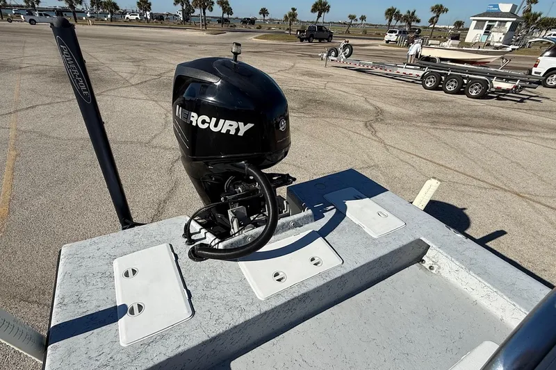 Slide: The Image of 2006 Shoalwater 21 Cat boat with Mercury outboard motor in parking lot. - 12