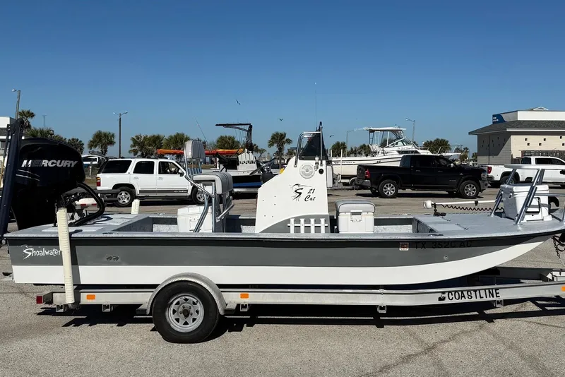 The Image of 2006 Shoalwater 21 Cat boat on trailer, parked in sunny marina lot. - 0