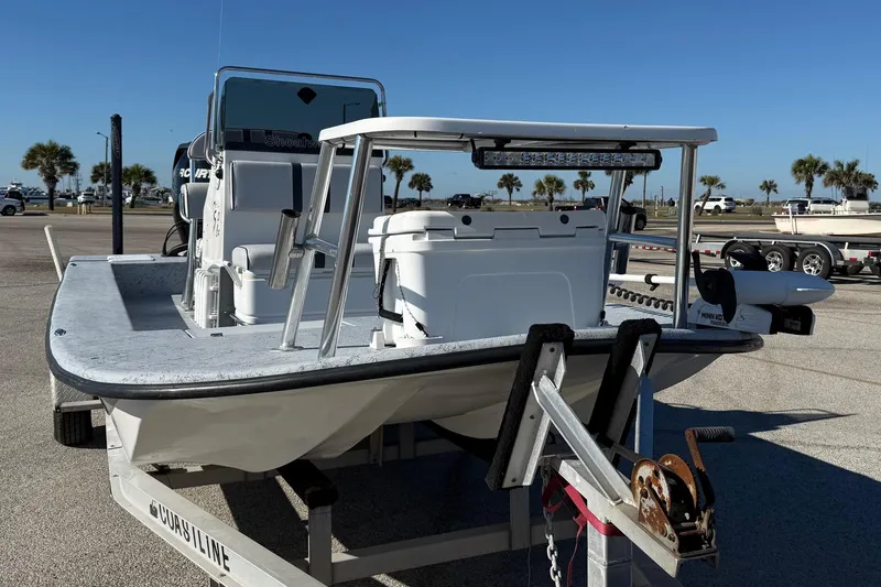 Slide: The Image of 2006 Shoalwater 21 Cat boat on trailer in sunny parking lot. - 2