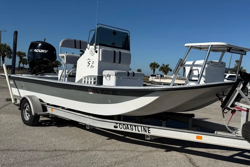 Slide: The Image of 2006 Shoalwater 21 Cat boat on trailer with Mercury engine, parked outdoors. - 3