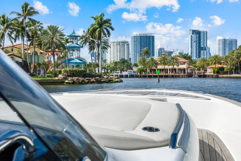 Slide: The Image of 2024 Solaris Power 44 yacht cruising near a tropical city skyline with palm trees. - 22