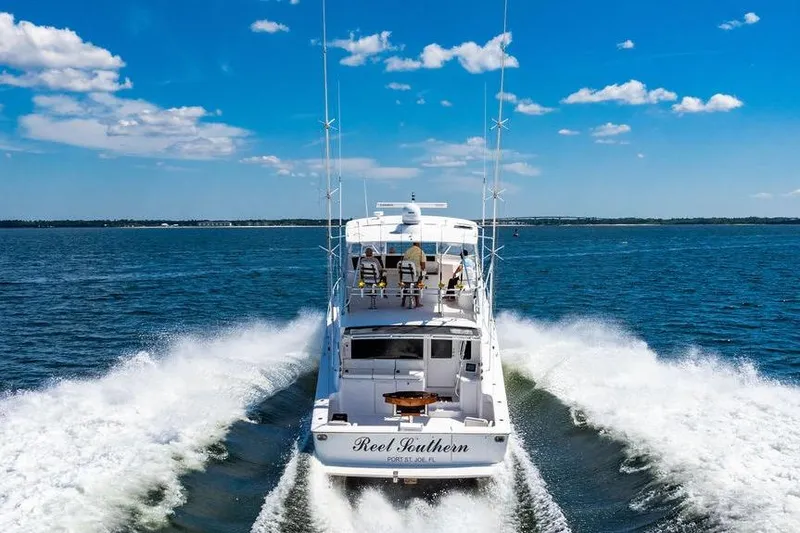 Slide: The Image of 2006 Viking 56 Convertible yacht cruising on open water under a clear blue sky. - 10
