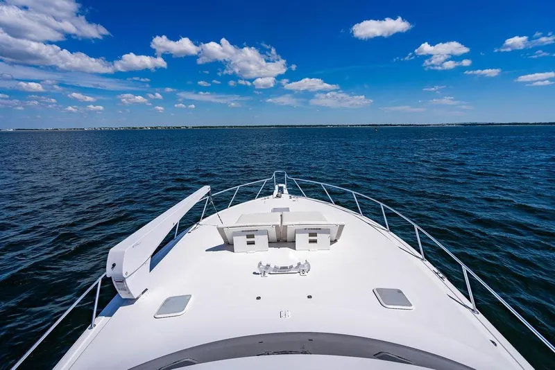 Slide: The Image of Bow view of 2006 Viking 56 Convertible yacht on open water under blue sky. - 30