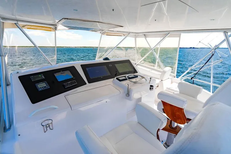 Slide: The Image of 2006 Viking 56 Convertible yacht helm with ocean view, featuring modern navigation equipment. - 34