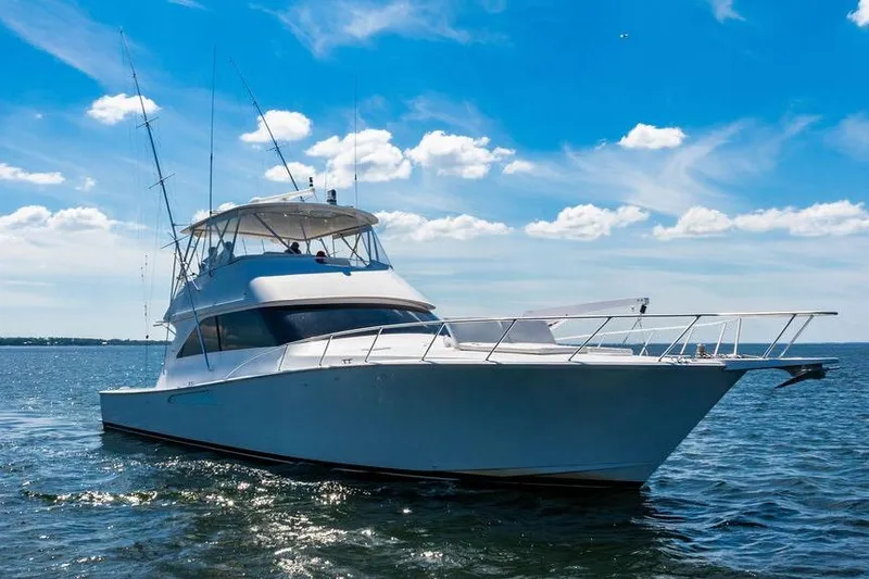 Slide: The Image of 2006 Viking 56 Convertible yacht cruising on open water under a clear blue sky. - 4