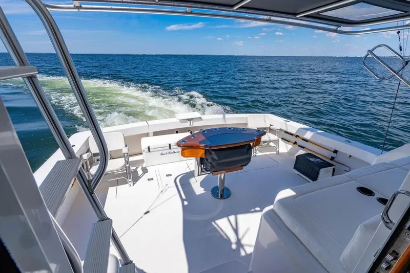 Slide: The Image of 2006 Viking 56 Convertible yacht cruising on open water, featuring spacious deck and seating. - 42