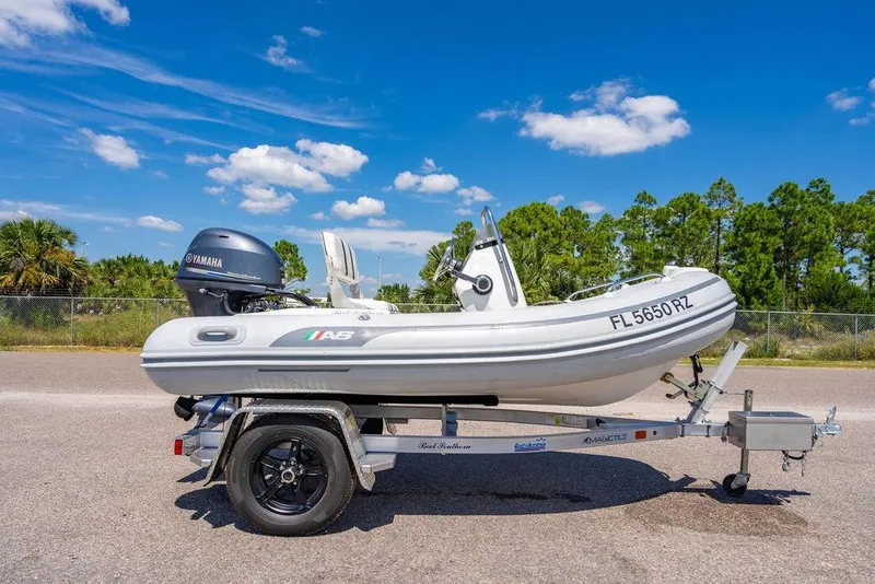 Slide: The Image of RIB boat on trailer with Yamaha engine under clear blue sky. - 56